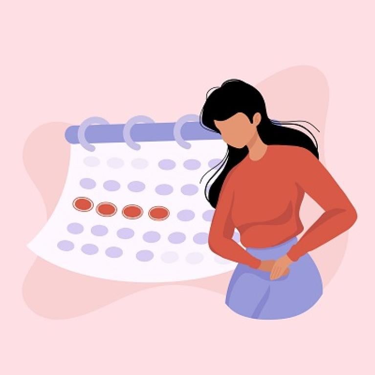 A woman in front of a calendar, and the calendar indicates the woman is on her period.