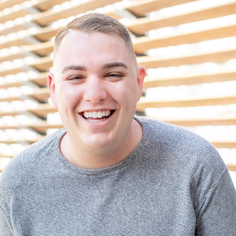 smiling man wearing a grey sweater