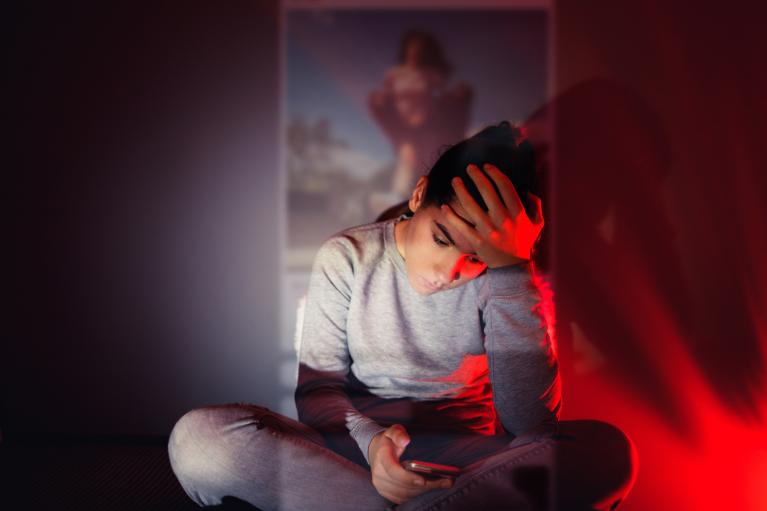 image of distressed person looking at cell phone