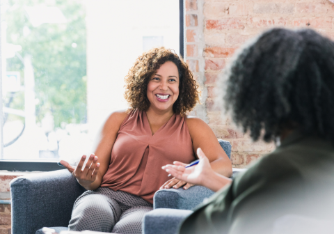woman sitting on a couch talking with her therapist