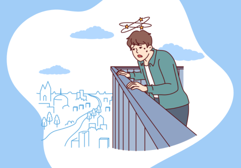 man standing on the top of a building looking down over the city and looking very scared.
