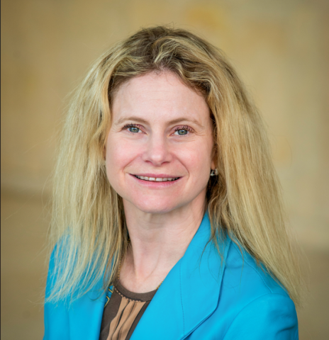 Headshot of a woman with blonde hair and blue eyes, wearing a turquoise blazer