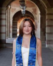 Jasmine Quach standing in a hallway wearing her graduation ribbon